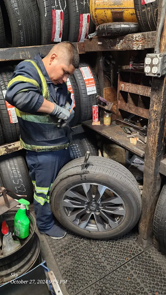 Mechanic working inside the shop surrounded by tires